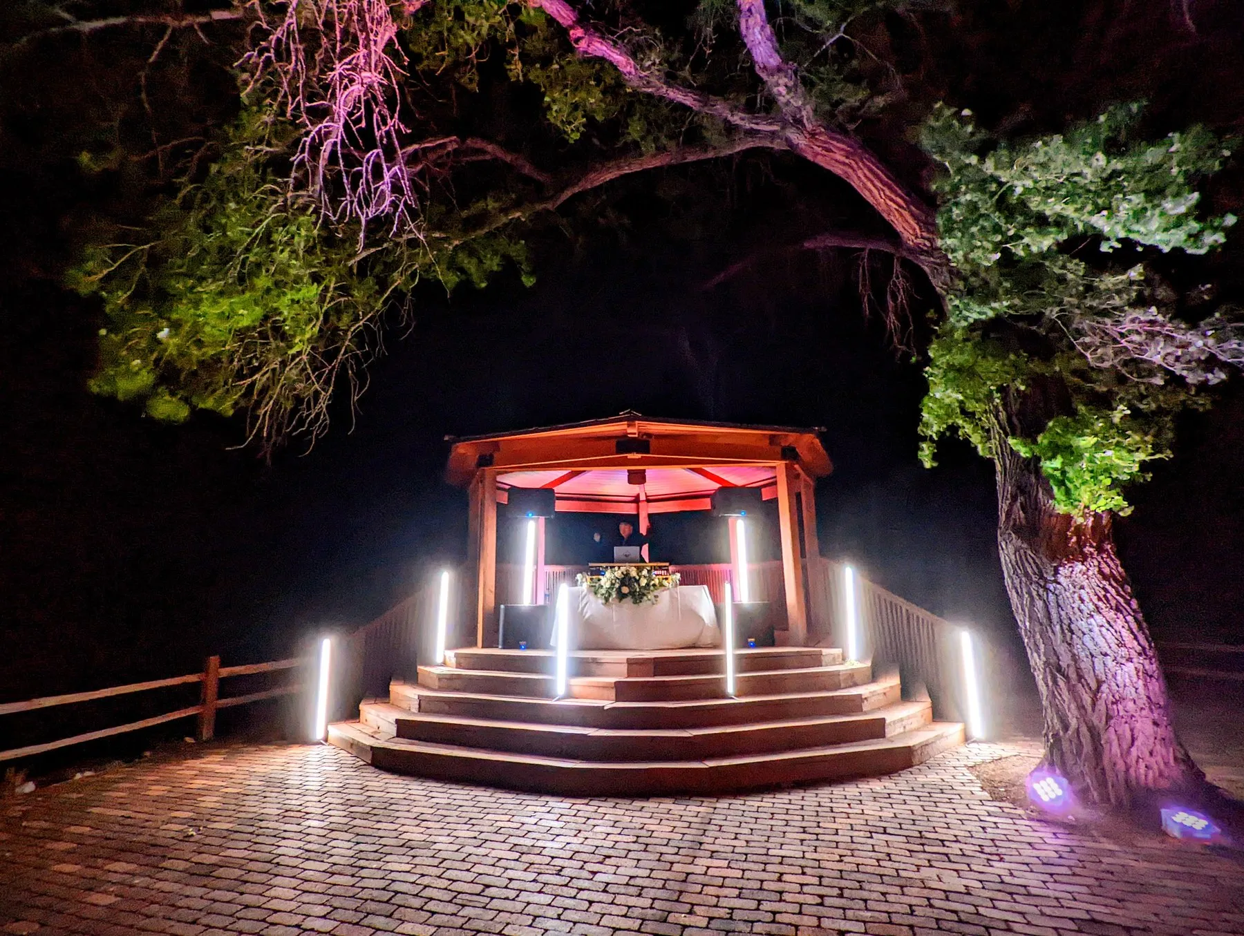 A Cutmaster Music DJ setup inside the Cottonwoods Pavilion gazebo at Hyatt Regency Tamaya, lit up at night under an old cottonwood tree